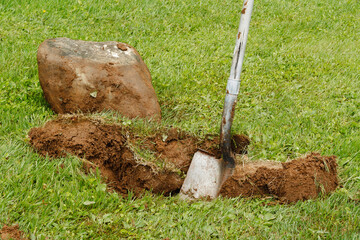 Large rock dug out the lawn with a shovel