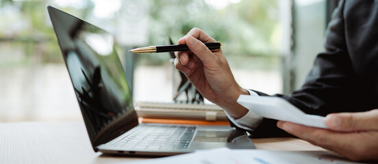Accountant working with computer tablet in modern office, preparing accounting analysis report,...