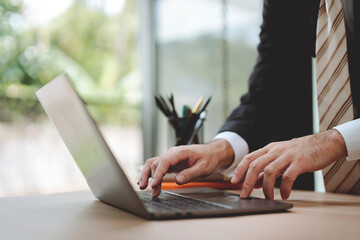 Close-up of typing on laptop computer keyboard. Working online in office, chatting on Facebook, meeting on website, blogger, journalist writing article, online work idea.