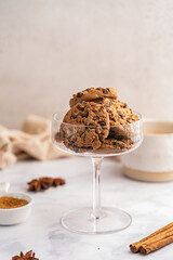 Golden chocolate chip cookies next to a glass of milk on white kitchen background. High quality photo
