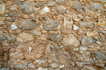 Ancient stone wall closeup in sunny day