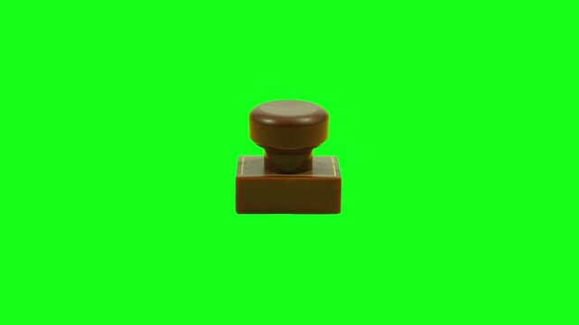 A smooth, brown, rectangular rubber stamp with a rounded top, isolated on a green screen