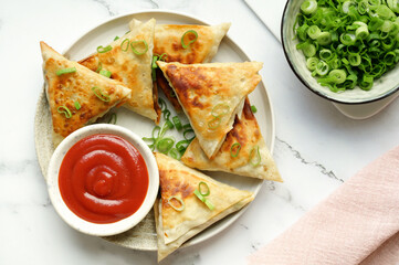 Homemade Indian samosas with golden-brown crusts with spicy dipping sauce.