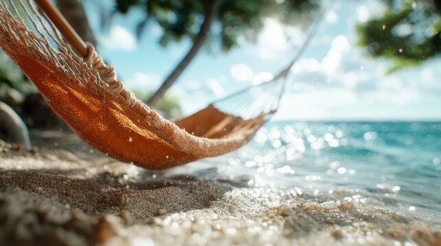 An inviting hammock sways gently by the shimmering waters of a beautiful beach, evoking feelings of relaxation, serenity, and a peaceful getaway in a tropical paradise.