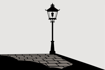 Old antique street lamp post illuminating the city street at dusk
