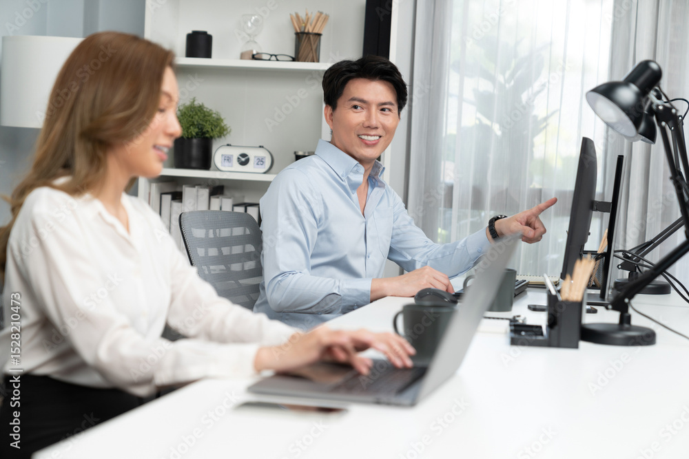 Poster smiling asian man talking with woman colleague in planning marketing report project on laptop casual