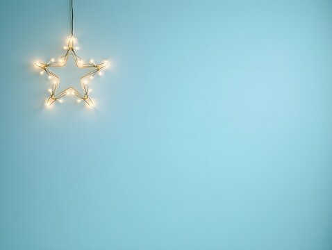 Christmas lights forming a bright star shape decoration on a pale blue background, perfect for holiday season greeting card or website banner Copy space for text