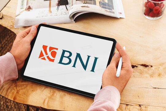 Man holding tablet showing bni logo on screen