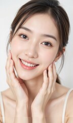 Young Thai woman with radiant smile, clear skin, natural makeup, and hands gently touching her face, isolated on white background, expressing happiness and confidence