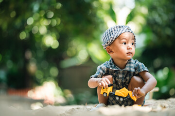 Curious toddler playing with sand outdoors, developing fine motor skills, creativity, and cognitive growth through hands-on exploration in a safe, natural learning environment under sunlight