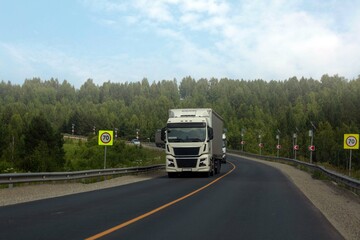 A truck is driving along the highway outside the city
