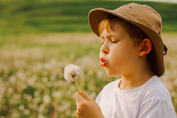 Close up of a child blowing dandelion seeds