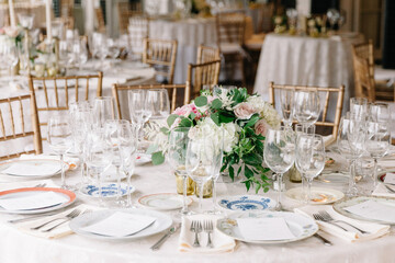 Elegant dining setup with floral centerpiece at a reception hall before an evening celebration