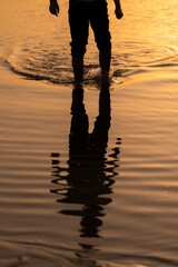 Reflejos de un hombre en la playa al atardecer