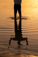 Reflejos de un hombre en la playa al atardecer