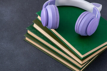 Wireless Headphones with books on black background