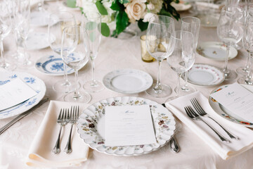 Elegant dining table set for a special occasion with floral centerpiece and assorted dishware