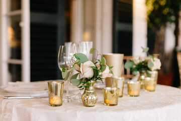 Elegant table setting with flowers and candles in a decorated dining area near evening light