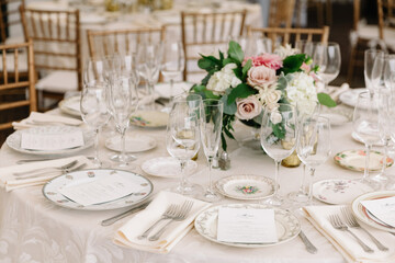 Elegant dining setup with fine china and floral centerpiece at a formal event in a decorated venue
