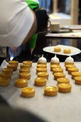 experto repostero elaborando bocaditos con tartaletas de hojaldre y crema pastelera