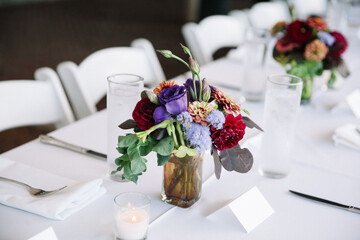 Centerpieces adorned with colorful flowers at a wedding reception in a cozy venue