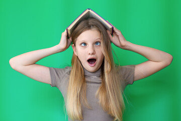 Surprised Girl Holding Book on Head. Blonde girl with shocked expression holding a book on her...