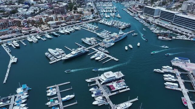 Aerial Cabo San Lucas Mexico marina boats descend. Resort city southern tip of Baja California peninsula. Beach and malecon markets. Eco tourism. Destination vacation and business. Commercial seaport.