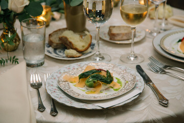 Elegant dinner setting with gourmet dish and fine wine at a beautifully arranged table