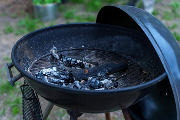 A wood grill with embers snuffed out.