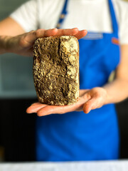Woman holding freshly baked sourdough loaf made with gluten free starter. Perfect for healthy baking blogs, organic food brands, and artisanal bakery promotions.