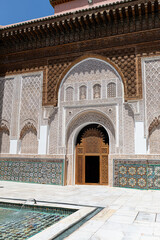 Traditional moroccan architecture featuring intricate carvings, colorful tilework, and a tranquil fountain in the courtyard of the ben youssef medersa