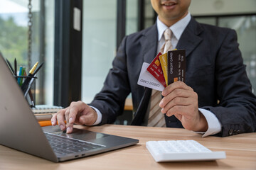 Businessman Holding Credit Cards at Desk