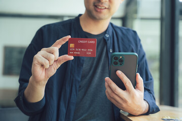 Man Holding Credit Card and Smartphone