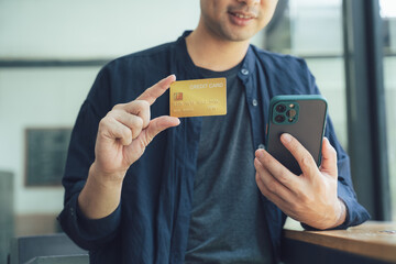Man Holding Credit Card and Smartphone