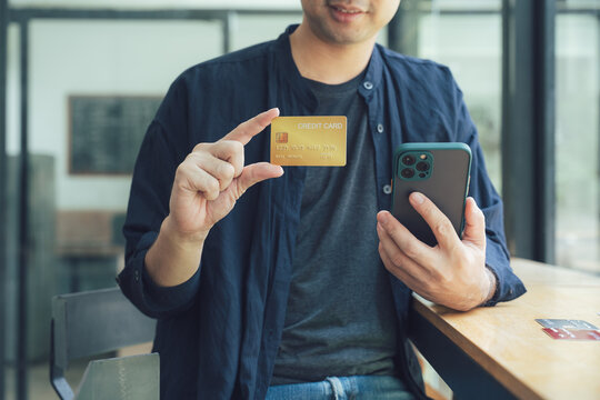 Man Holding Credit Card and Smartphone