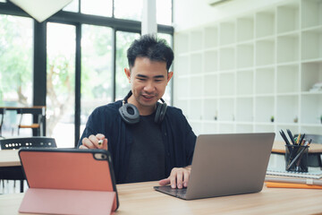 Man Working at Desk with Laptop and Tablet