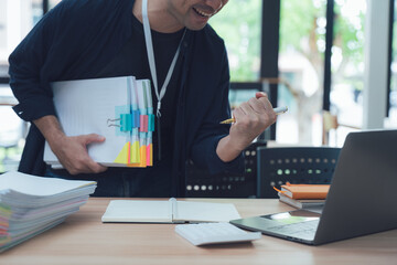 Excited Man Celebrating Success with Documents and Laptop