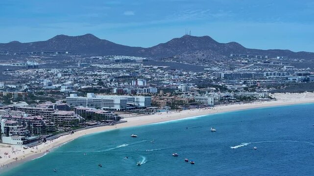 Aerial Cabo San Lucas Mexico ocean bay to city b. Resort city southern tip of Baja California peninsula. Beach and malecon markets. Eco tourism. Destination vacation and business. Commercial seaport.