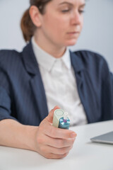 Business woman smoking an electronic cigarette while working on a laptop. Tobacco heating system. 