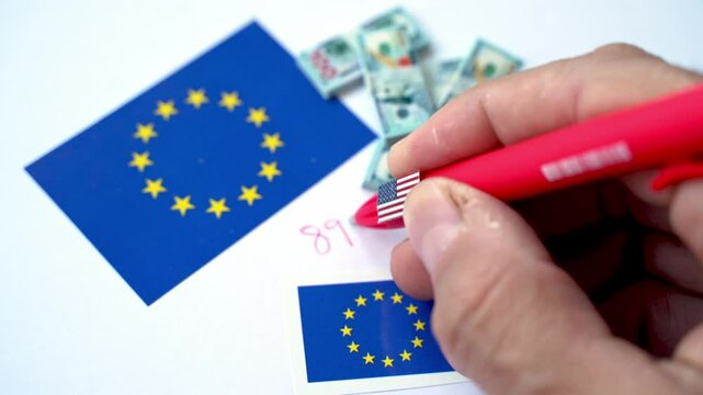 Hand writing 899 act regulation number near European union and USA flag with dollar banknotes, referring to US Tax Law Impacting EU-US Economic Relations