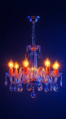 A crystal chandelier with six lit incandescent bulbs hangs against a deep blue background;  the glass is clear and faceted, reflecting light, creating a dazzling effect.  The chandelier features a
