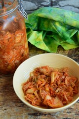 Napa cabbage kimchi in a bowl and jar, Korean fermented side dish food.

