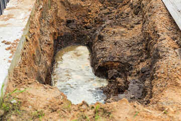 Leak from a broken water pipe in a trench near a construction site causing disruption and potential...