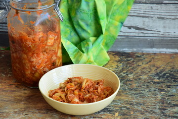 Napa cabbage kimchi in a bowl and jar, Korean fermented side dish food.
