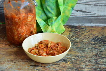 Napa cabbage kimchi in a bowl and jar, Korean fermented side dish food.
