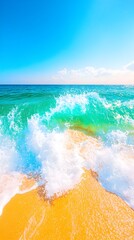Vibrant turquoise waves crash onto a golden sandy beach under a clear blue sky, creating a picturesque summer seascape