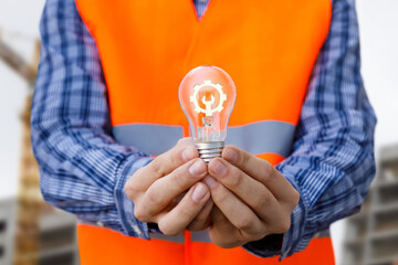 Worker holding light bulb symbolizing innovation