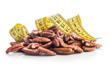 Peeled pecan nuts and measuring tape isolated on white background.