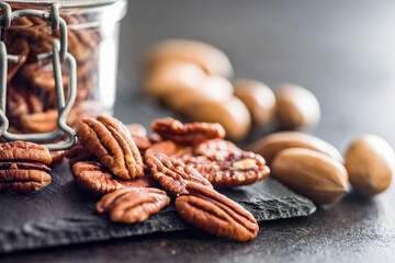 Peeled pecan nuts on black table.