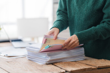 Woman Organizing Paperwork on Wooden Desk